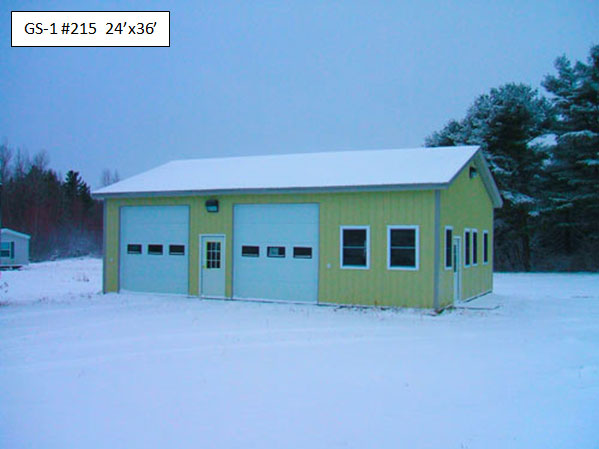 A steel building with snow covering its roof and surrounding the building