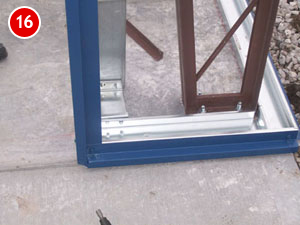 Close-up of a metal and wooden frame on a concrete surface, reflecting steel building construction techniques, with a red circular label displaying the number "16" in the top left corner.