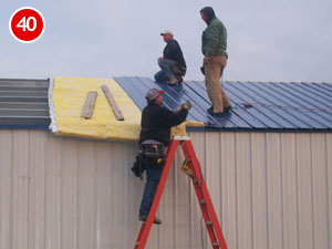 installing insulation and roof sheet metal on building kit