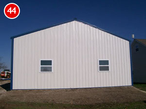 A cream-colored steel building with a blue roof trim stands proudly. The structure features two small windows against a clear blue sky. Highlighting its sturdy construction, the number 44 is displayed in a red circle at the top left corner of the image.