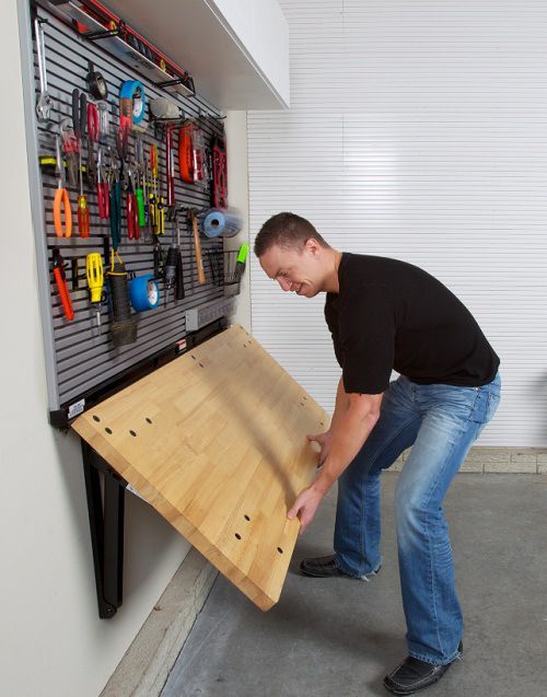 A man putting together a work bench with tool storage
