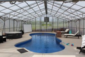 pool covered by steel building kit with clear sides