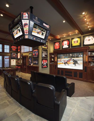 A home theater with sports memorabilia on the walls and two rows of recliners