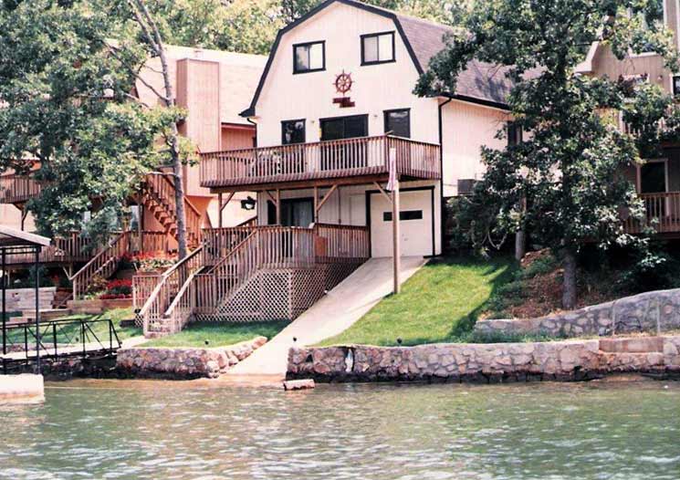 A steel framed lake house with a deck and patio designed and built by Worldwide Steel Buildings