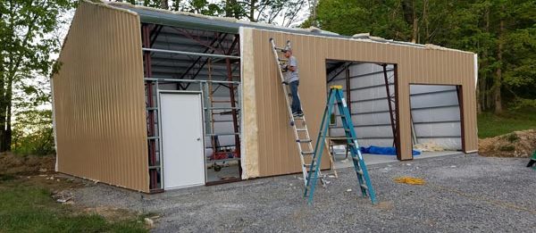 Worldwide Steel Buildings installing the final wall of an outdoor garage.