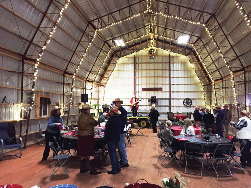 An indoor view of a metal building wedding venue with a live band performing and a reception going on