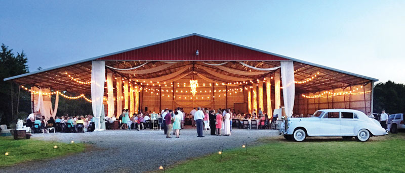 An outdoor metal building wedding venue with a wedding reception taking place