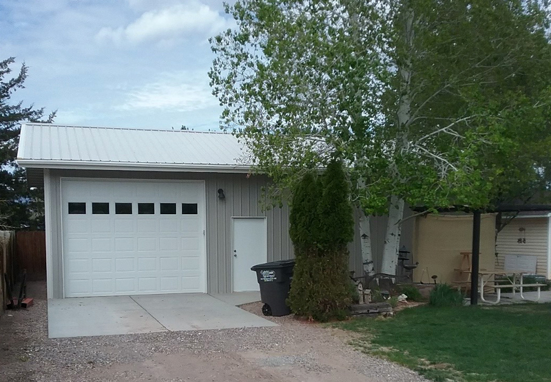 Russ and Ranae's custom metal workshop exterior featuring a large overhead door by Worldwide Steel Buildings.