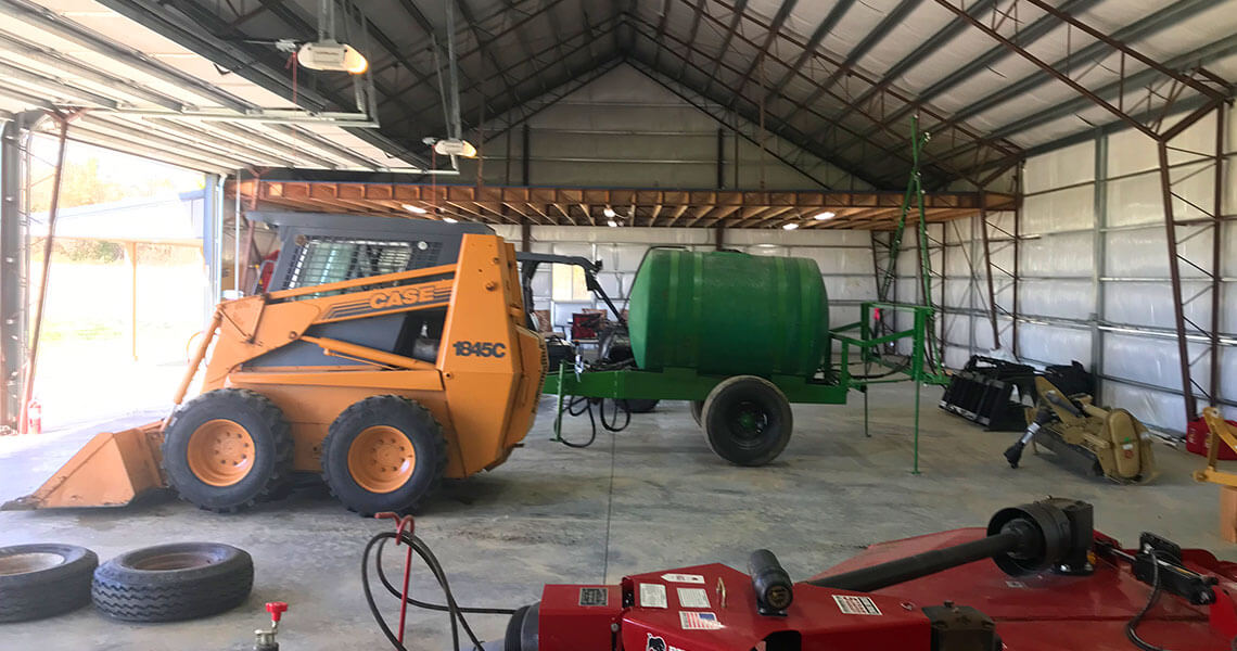 Large equipment stored in a custom steel garage at Overbrook Farms by Worldwide Steel Buildings