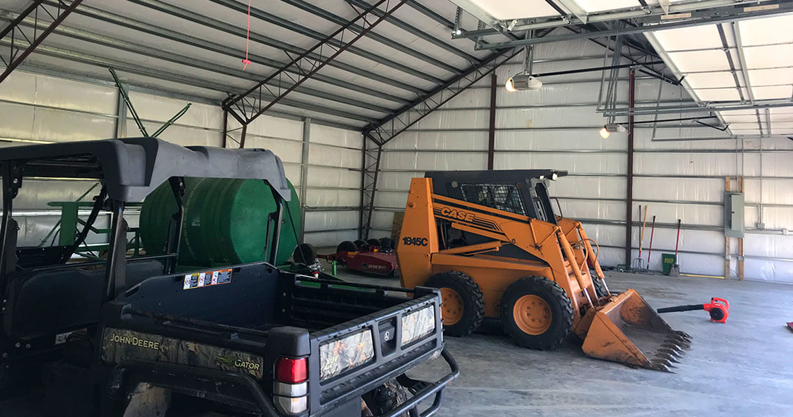 Overbrook Farms work equipment stored in their steel garage from Worldwide Steel Buildings