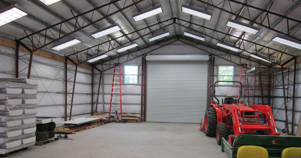 Interior of garage with a tractor parked to one side.