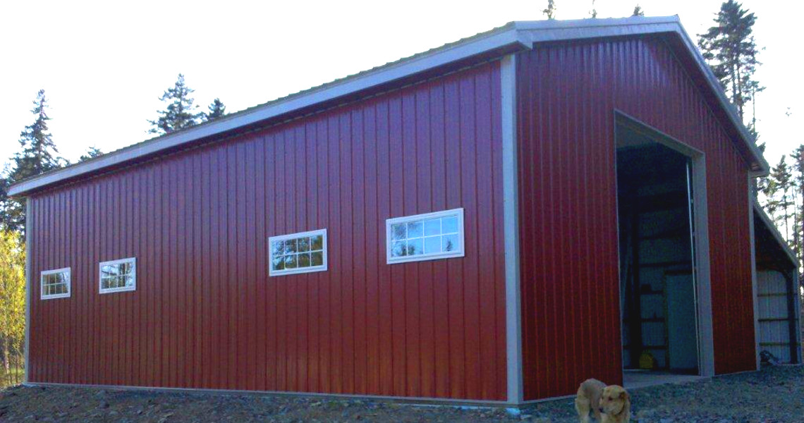 A red building that was built by Worldwide Steel Buildings that features a half truss roof.