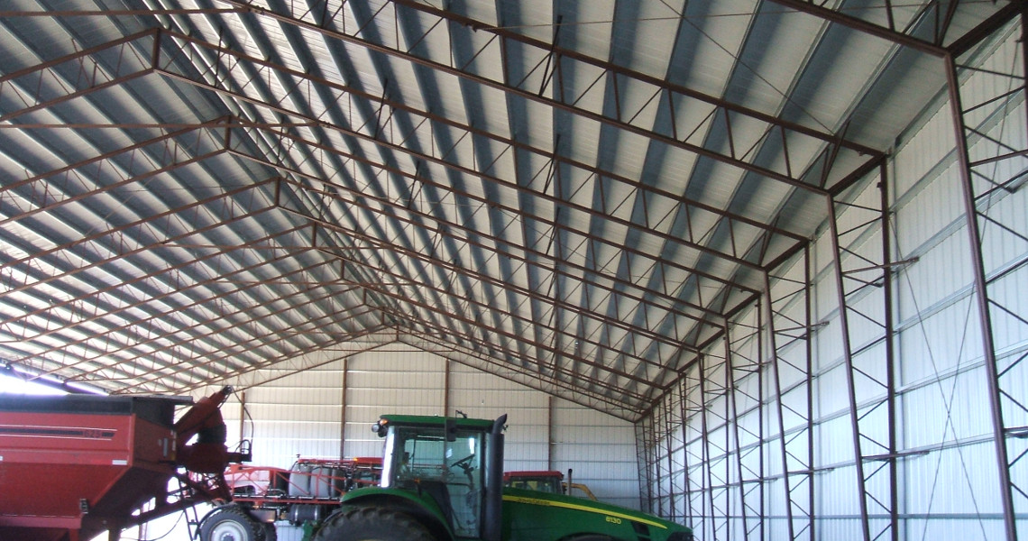 An interior shot of a storage building designed and built by Worldwide Steel Buildings with two tractors inside