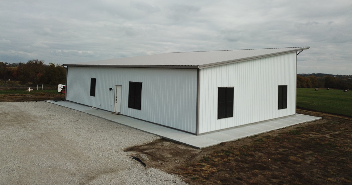 An exterior shot of a metal barndominium designed and built by Worldwide Steel Buildings featuring a single slope roof.