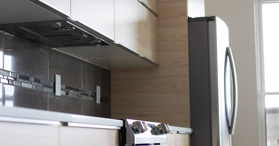 A close up shot of the kitchen inside of a metal barndominium featuring light wood and stainless steel.
