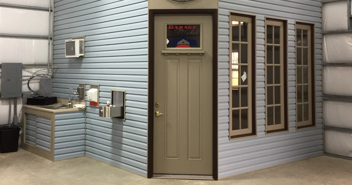 A small room with light blue siding evokes a touch of paradise, featuring three tall windows and a door adorned with a 