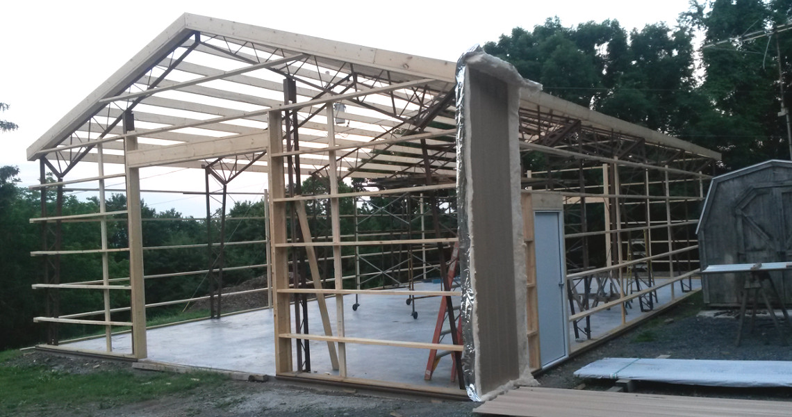 A hybrid building being built by Worldwide Steel Buildings with the wooden frame completed.