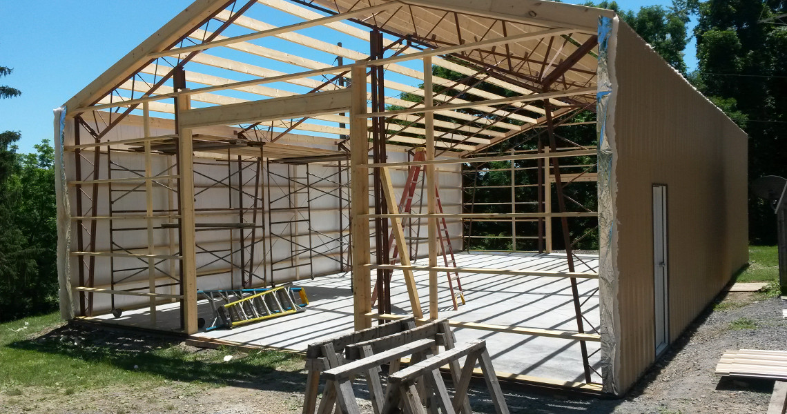 A hybrid building being built by Worldwide Steel Buildings with two of the four walls finished.