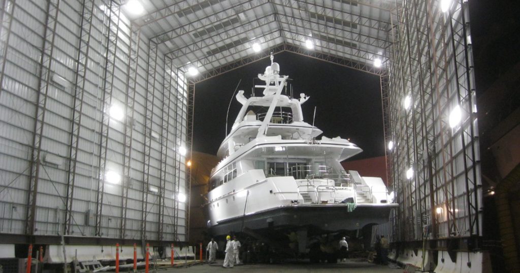 A large, white yacht inside of an outdoor steel garage
