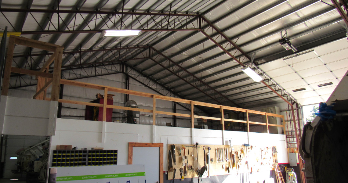The interior of Caskey Trucking's custom steel building with a loft and overhead doors from Worldwide Steel Buildings.