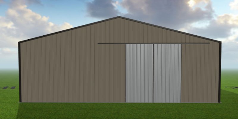 A large, brown metal barn with a gray Spring Hill Slider sits on a green grass field under a blue sky with scattered clouds.