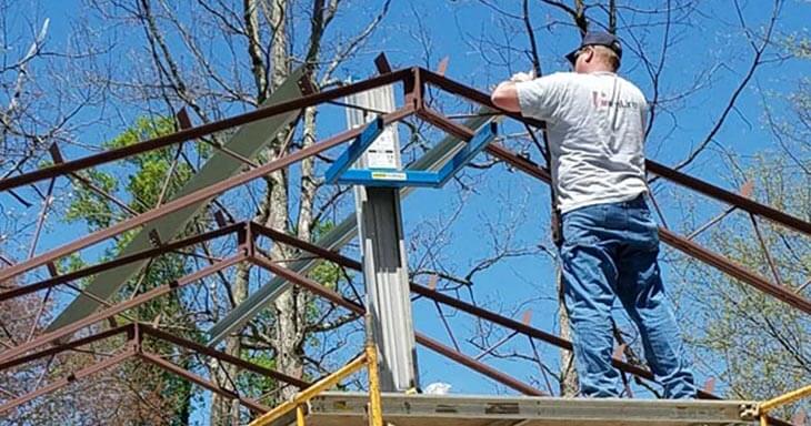 A construction worker building a metal building roof