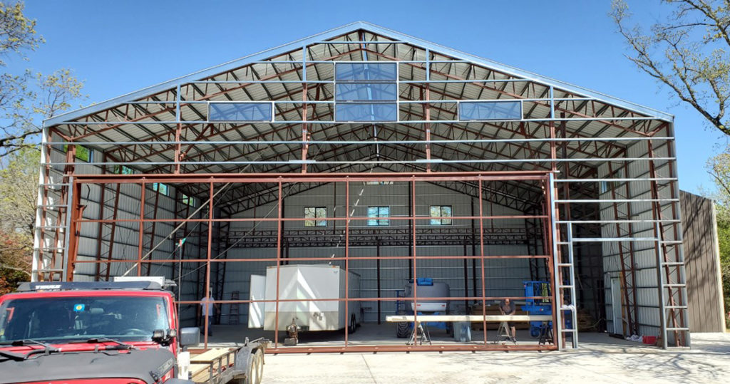 Construction progress photo of a metal airplane hangar.
