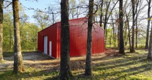 A red steel outdoor workshop built in Alton, MO by Worldwide Steel Buildings.