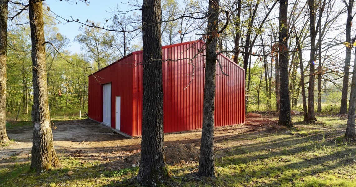 A red steel outdoor workshop built in Alton, MO by Worldwide Steel Buildings.