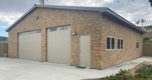 A steel garage with a brick exterior built in Riverside, CA by Worldwide Steel Buildings.