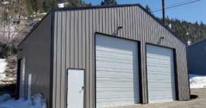 A light gray steel garage built in June Lake, CA by Worldwide Steel Buildings.