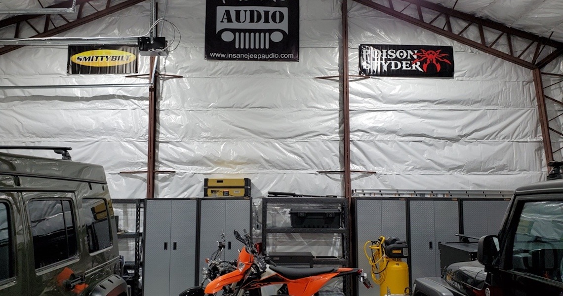 A California garage showcases a motorcycle in the foreground, with walls adorned with banners for 