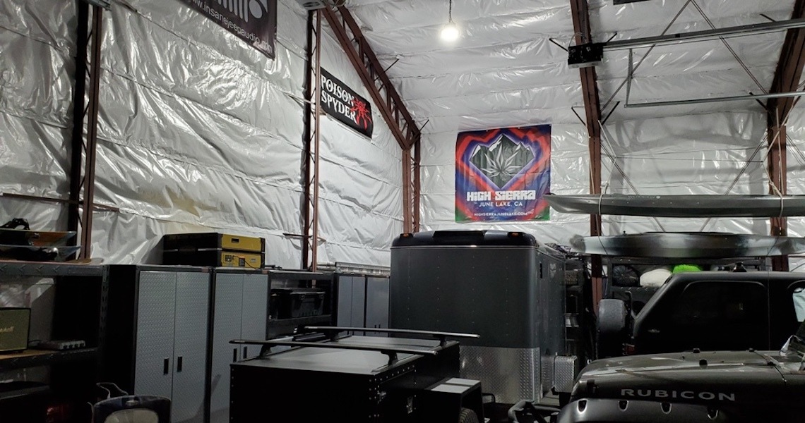 Inside the expansive garage, vehicles, cabinets, and equipment fill the space. Banners adorn the walls, one proudly declaring 