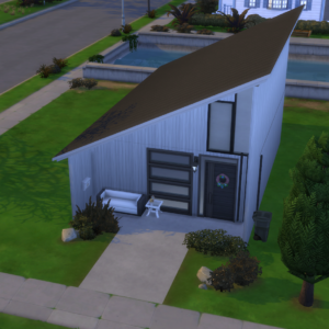 The Watson: 20x30 Tiny House Kit is a compact, contemporary home showcasing a slanted roof, white exterior, and expansive windows. A walkway leads to the entrance, accented by a white bench and small table. The lush green lawn is bordered by shrubs and a towering tree, with views of nearby streets and another house.