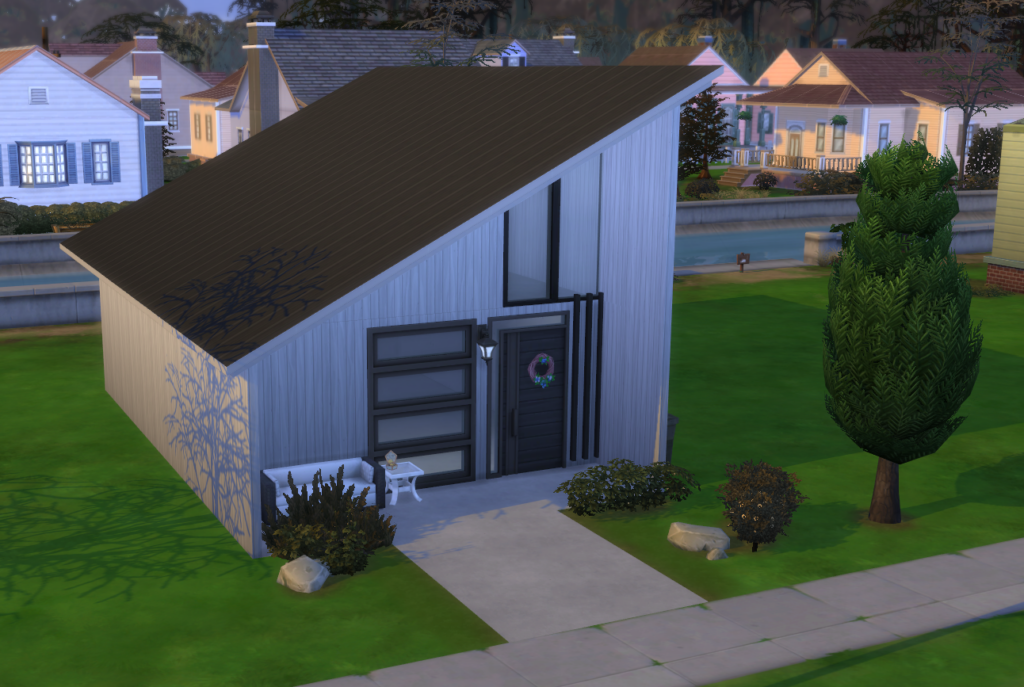 A large, black industrial building, Ref#071142, with a gabled roof stands on a green grassy field. This 50x84x14 all-steel structure features multiple tall rolling doors on one side and a few windows. The sky is partly cloudy with blue and gray tones.