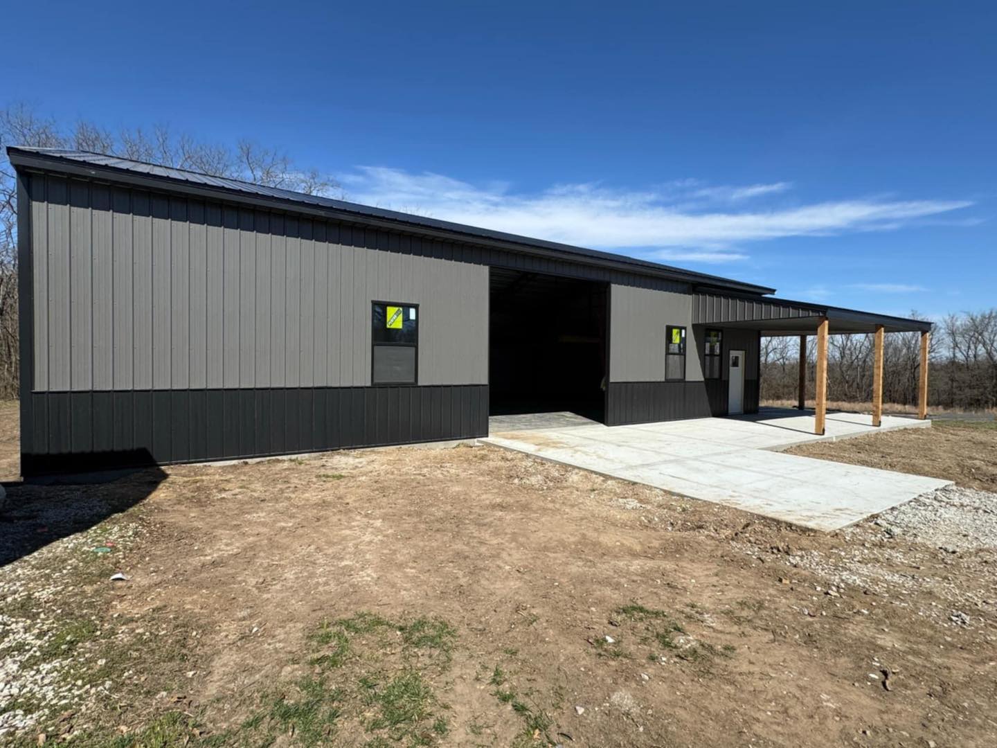 Litchford Garage: Rectangular metal building, gray-black exterior, open door, trees in the background.