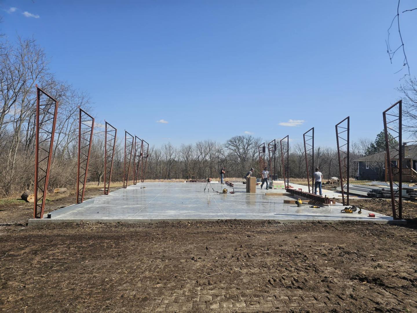 Construction in Litchford: steel beams and workers on site, ideal shop spot, surrounded by trees.