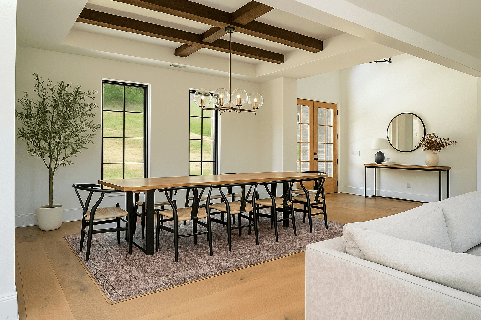 Modern dining room with wood table, black chairs, chandelier, large windows, and ceiling beams.
