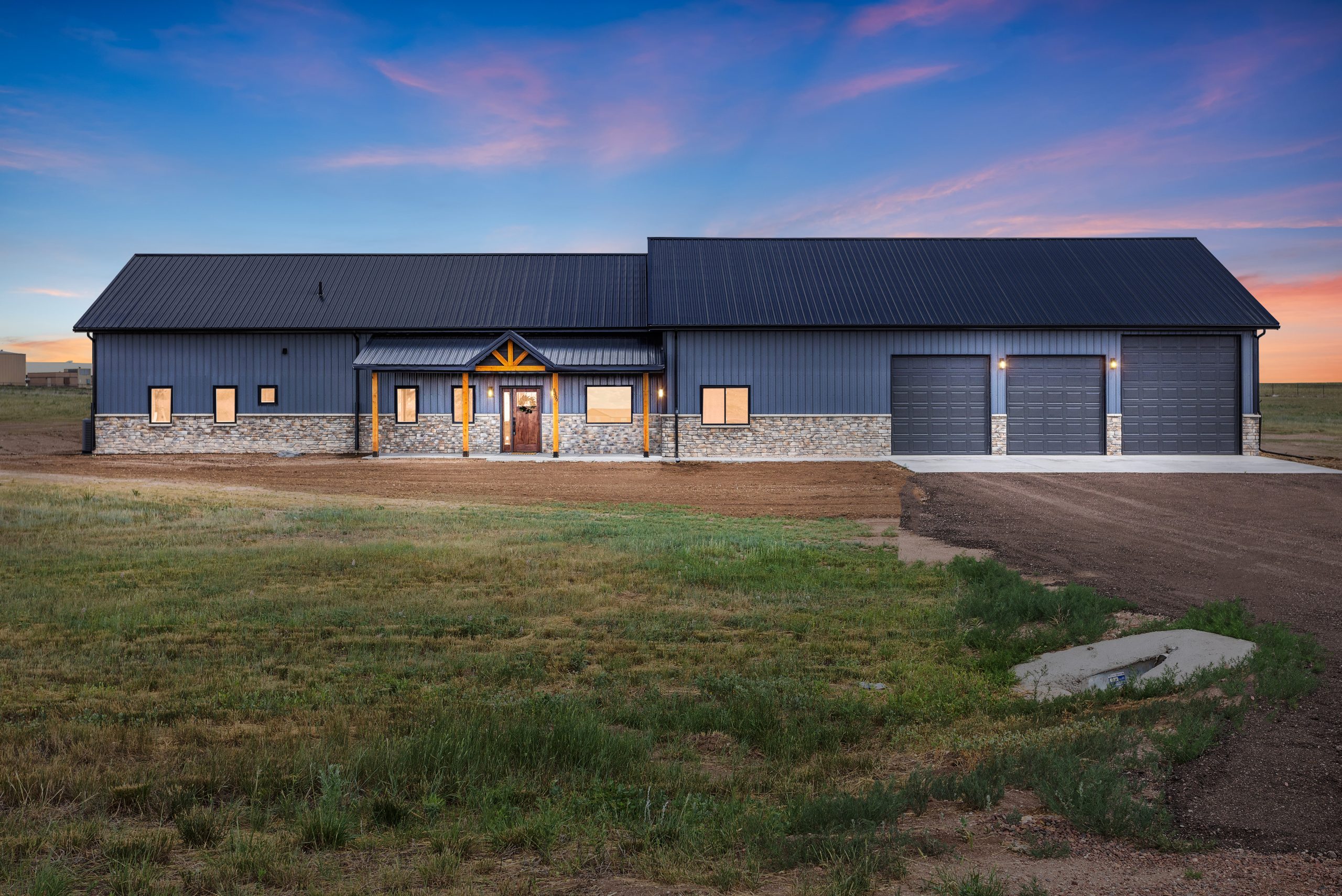 60x34 black gable barndominium exterior front with an overhang and porch entryway in Cheyenne, Wyoming