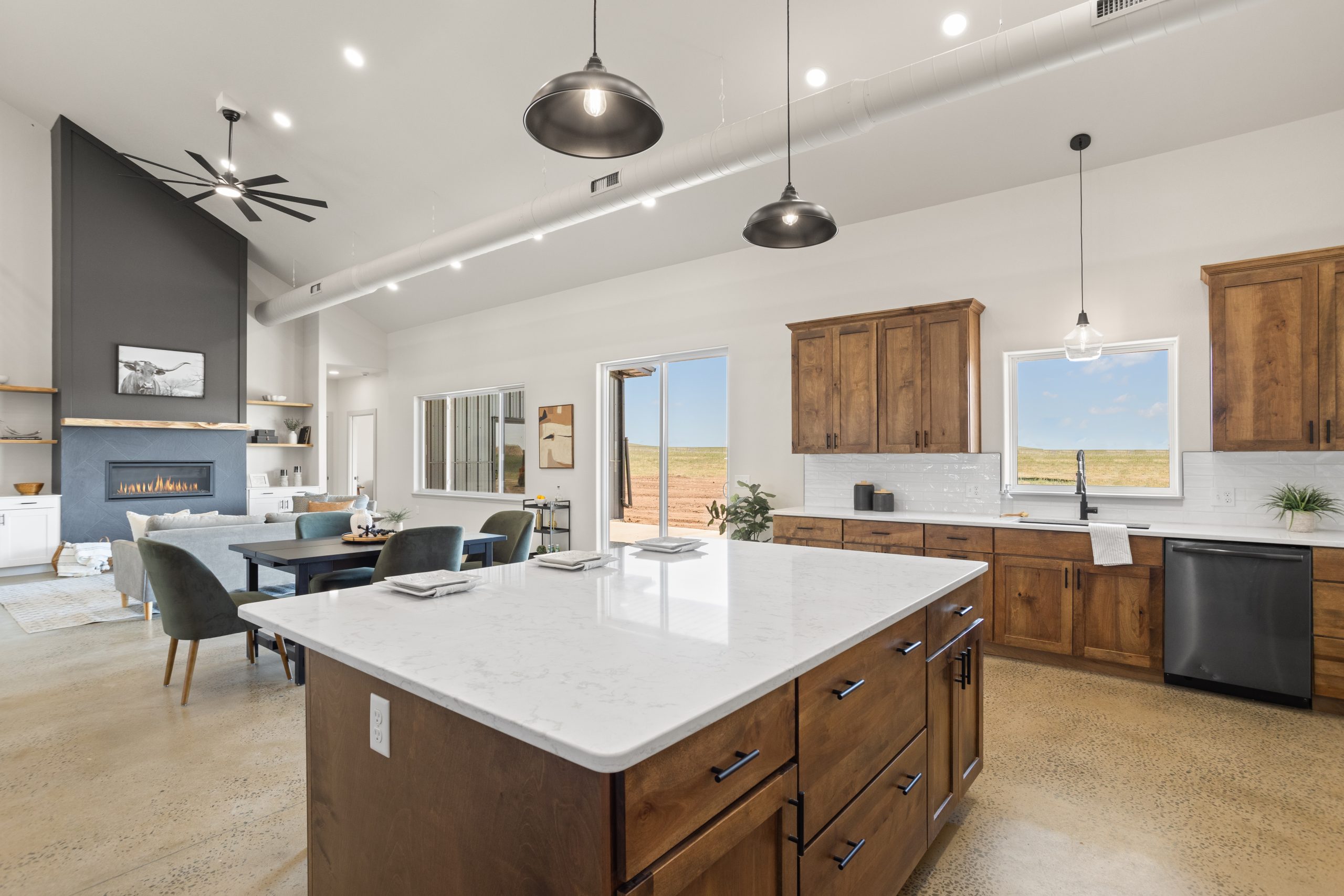 Kitchen with an island and cabinetry next to the living room in a barndominium in Cheyenne, Wyoming