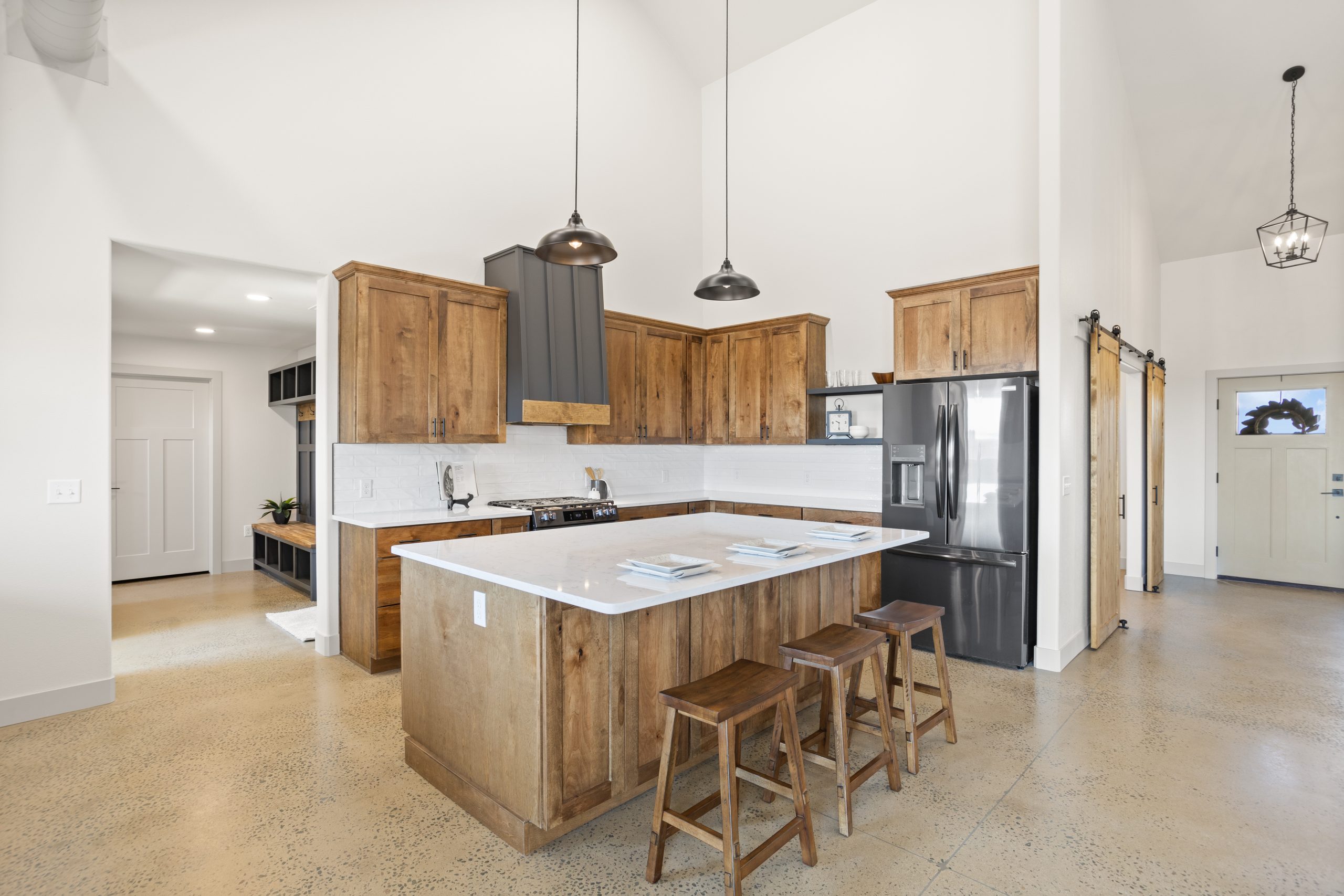 Kitchen with fridge and cabinetry next to mudroom inside a barndominium in Cheyenne, Wyoming