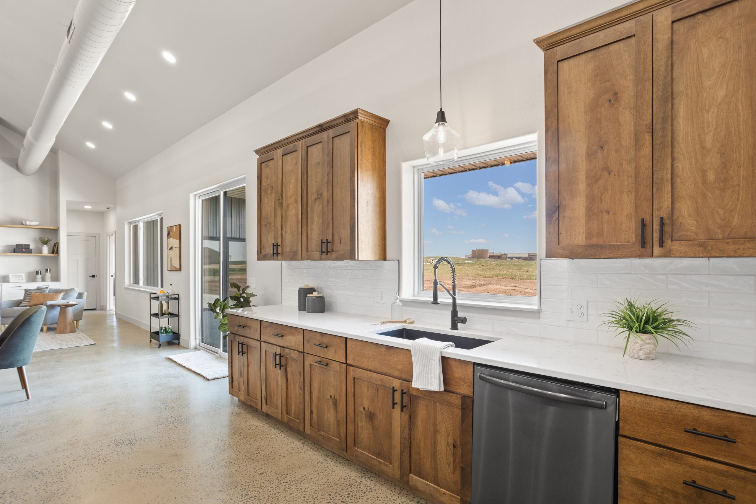 Kitchen cabinetry and countertop next to the living room inside a barndominium in Cheyenne, Wyoming