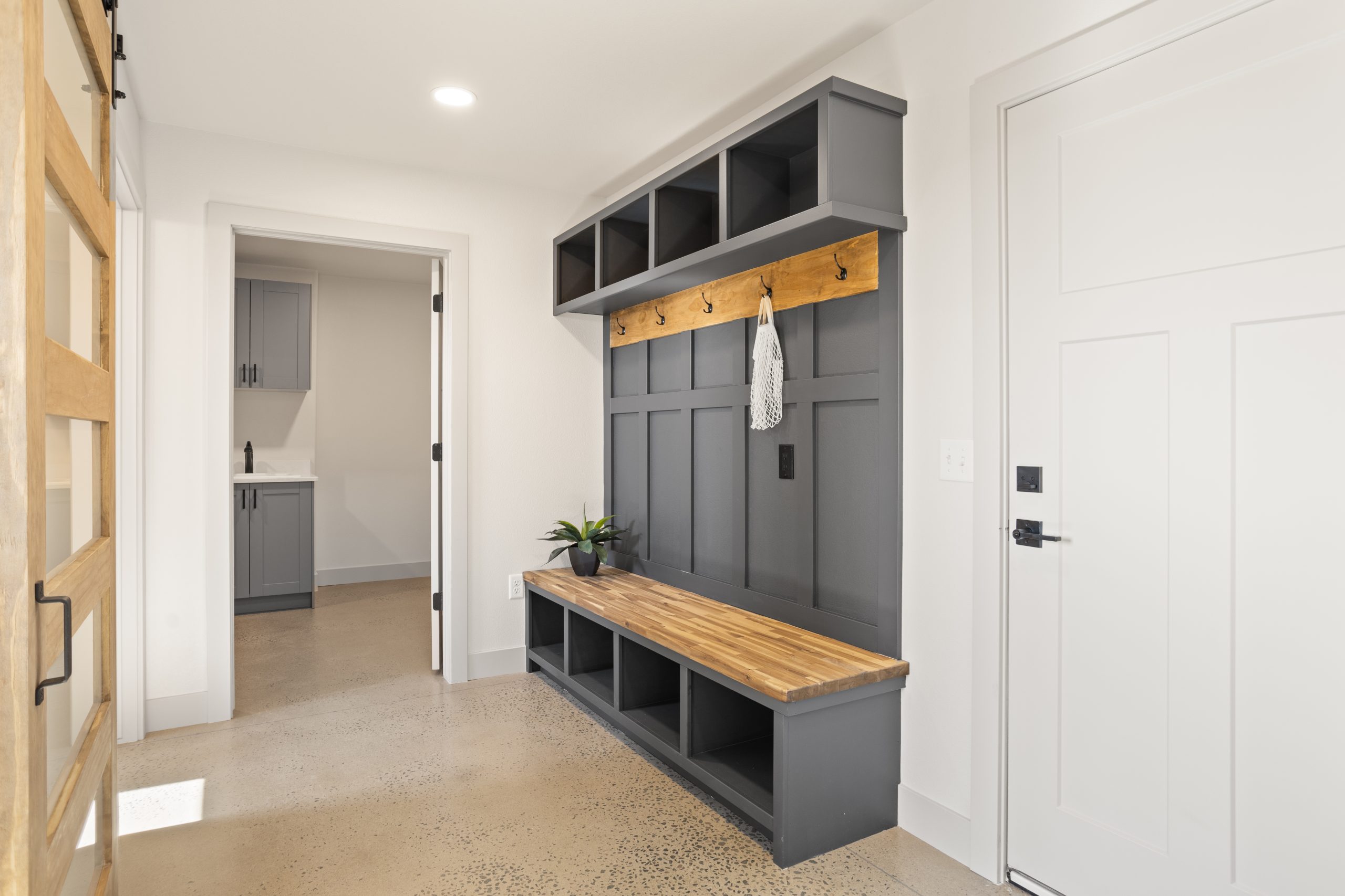 Mudroom and bench with storage cubbies and wall hooks inside a barndominium in Cheyenne, Wyoming