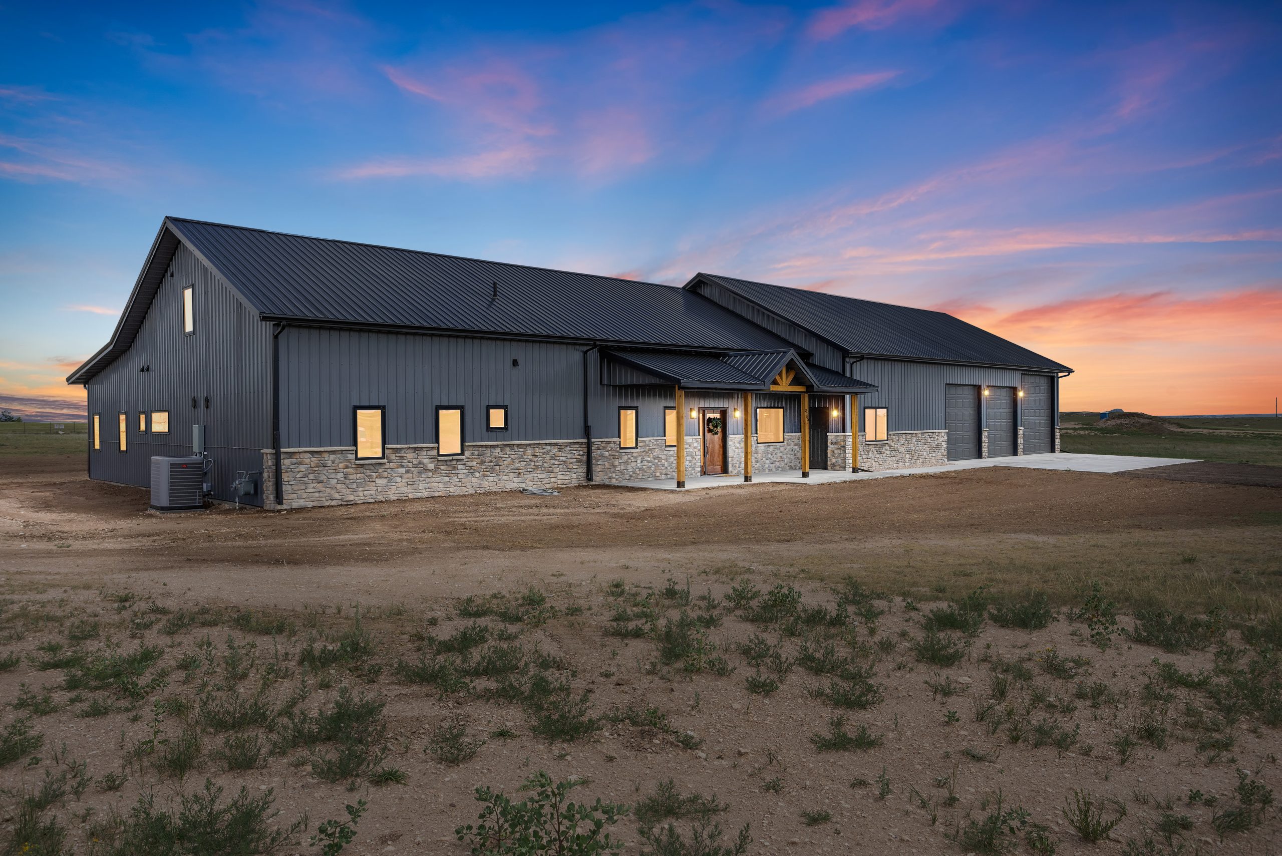 60x34 black gable barndominium exterior with an overhang and porch entryway in Cheyenne, Wyoming