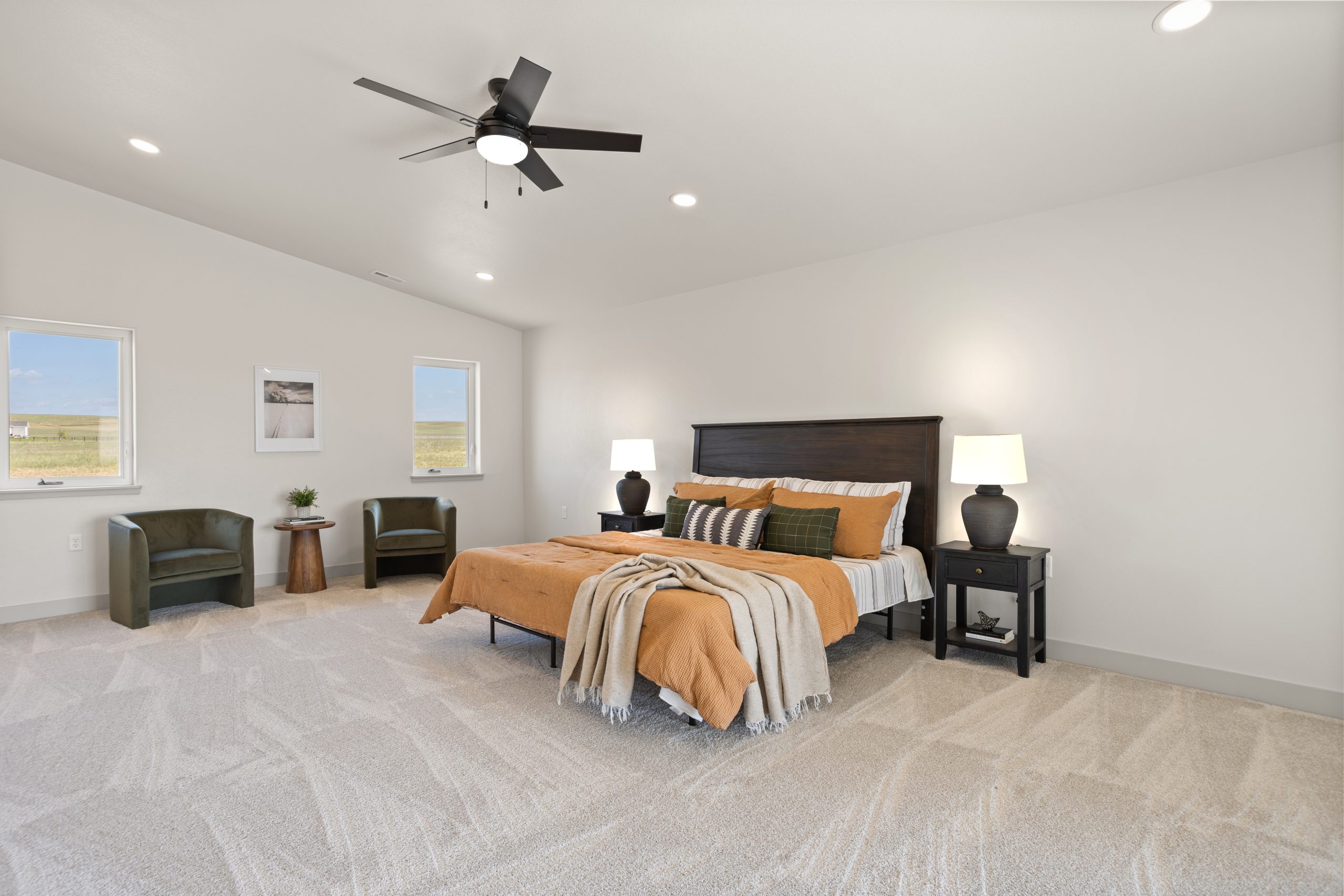 Furnished bedroom with a bed, chairs, and nightstands inside a barndominium in Cheyenne, Wyoming