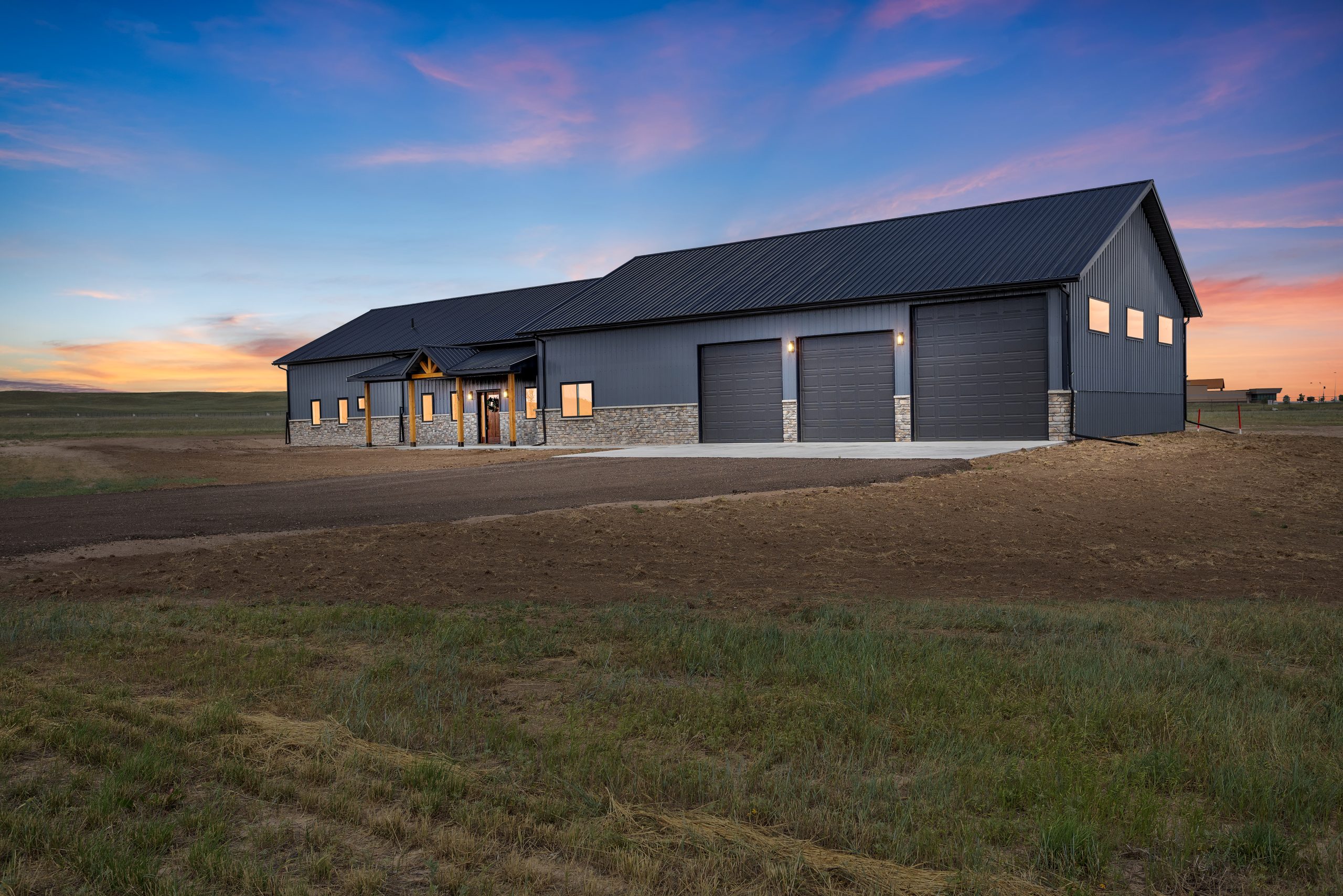 60x34 black gable barndominium exterior with a garage and covered porch entryway in Cheyenne, Wyoming