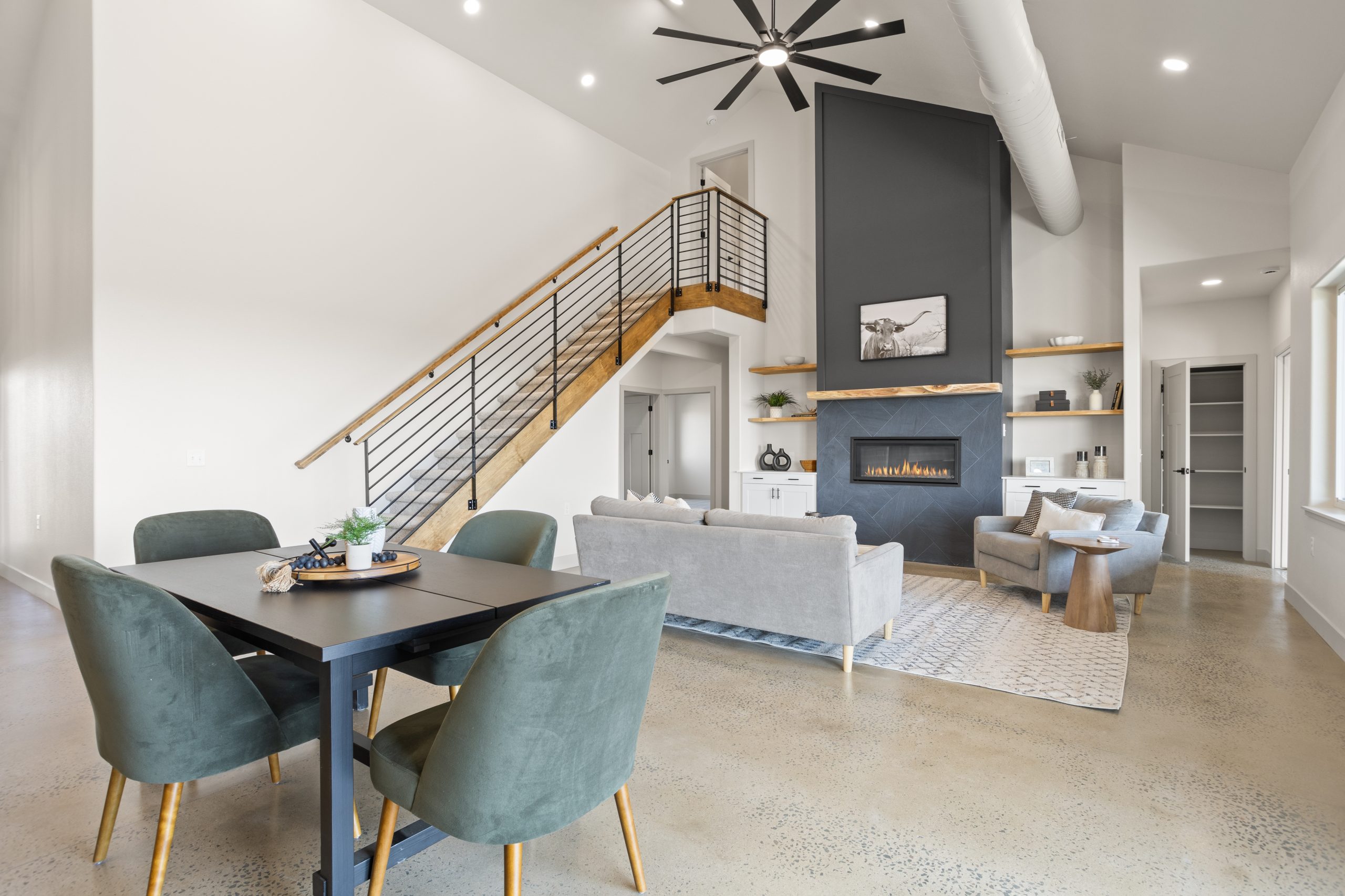 Living room with a staircase and fireplace inside a barndominium in Cheyenne, Wyoming